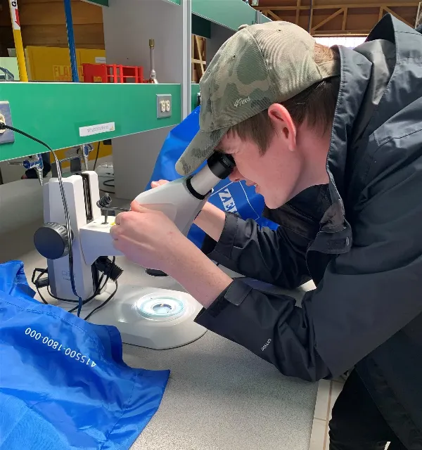 student using microscope