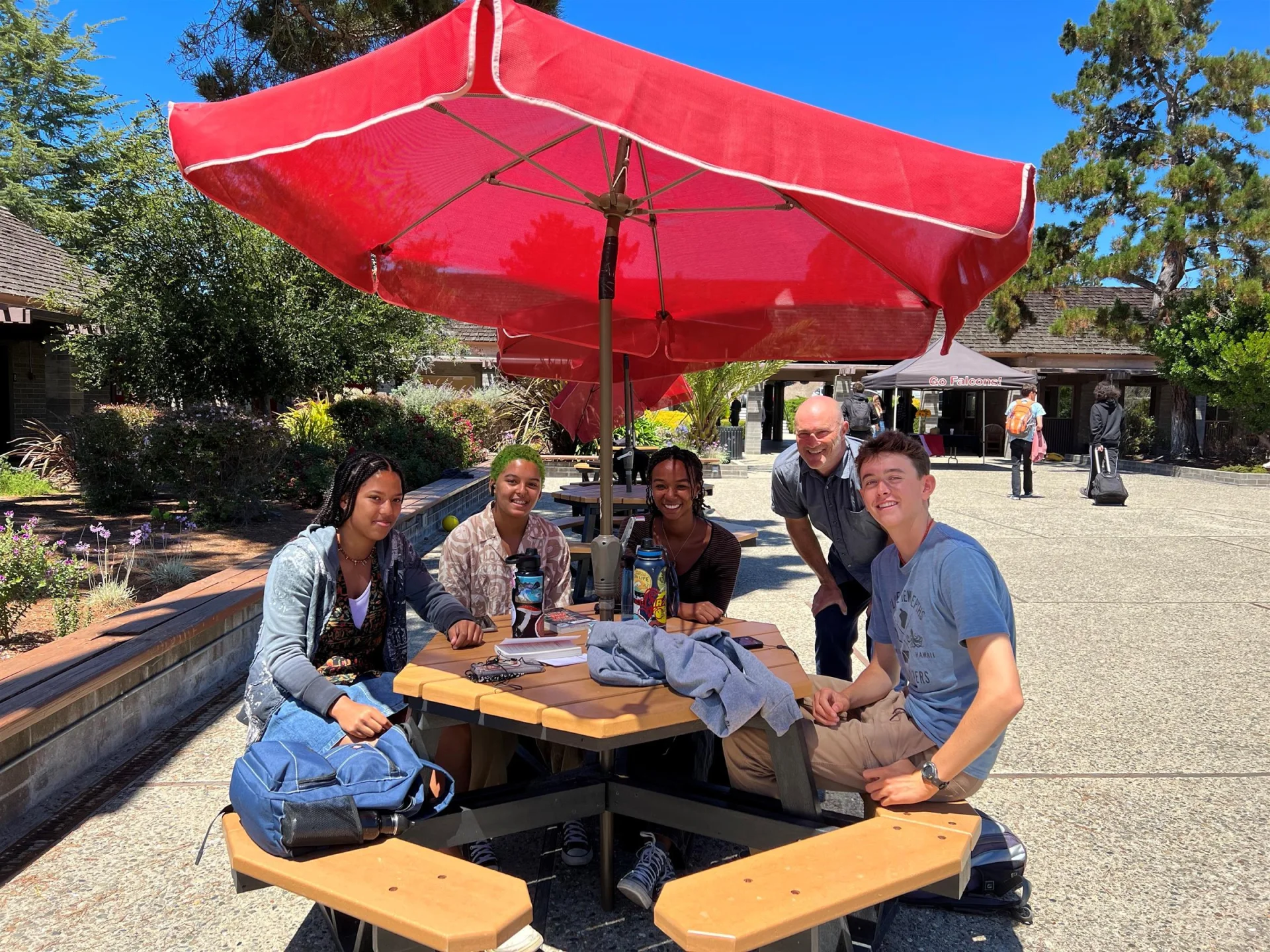 group of students sitting at an outdoor table